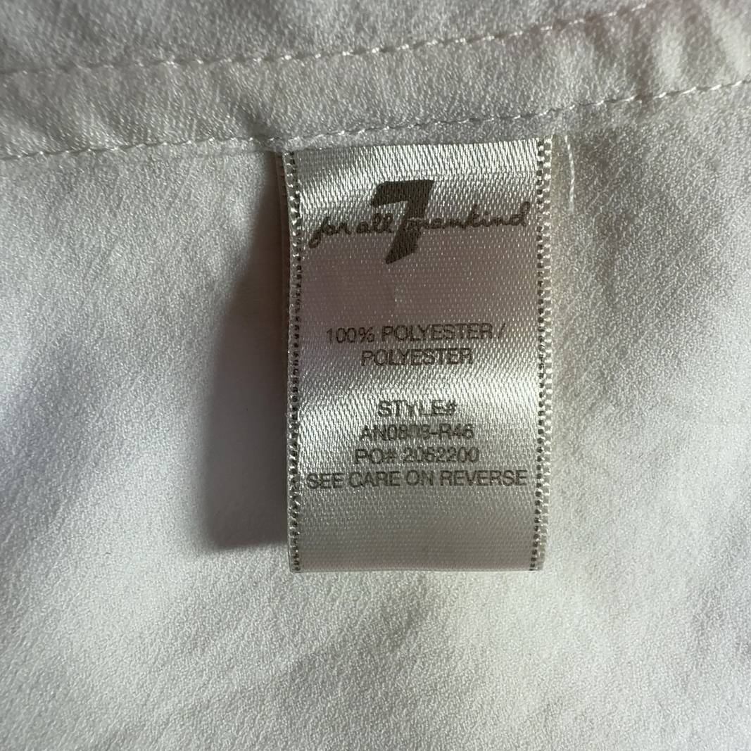Tag view of cream collared blouse showing button-up closure and relaxed fit silhouette