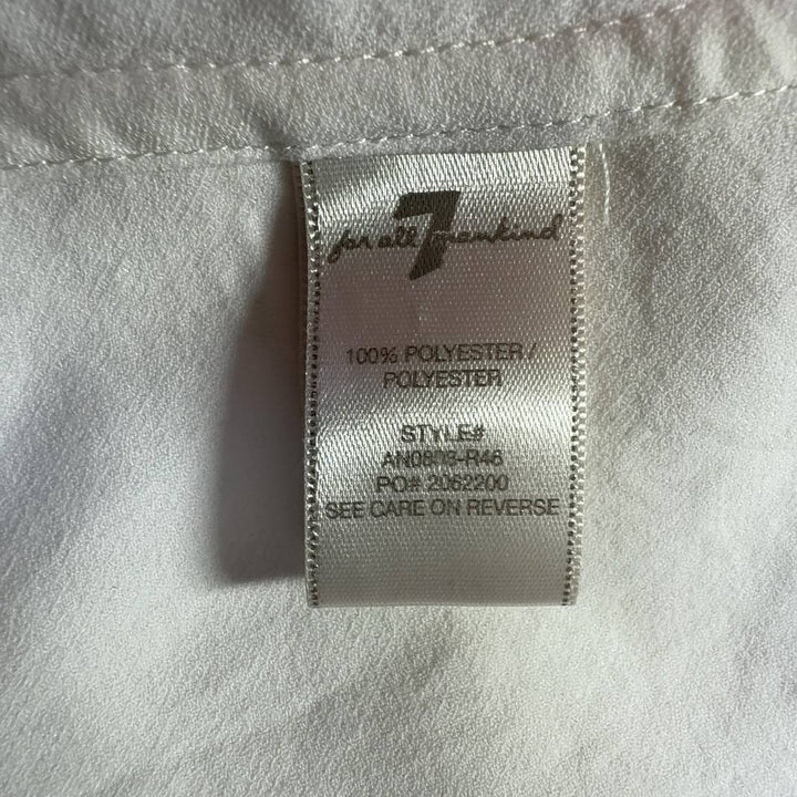 Tag view of cream collared blouse showing button-up closure and relaxed fit silhouette
