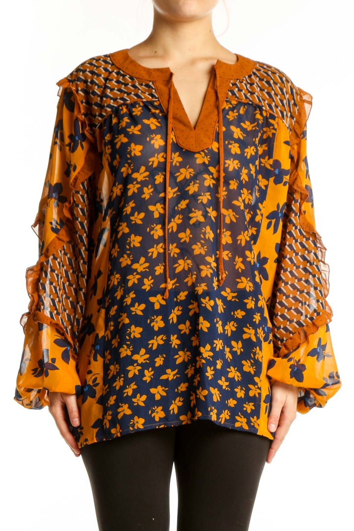 Navy and orange floral Cabi blouse with textured bell sleeves and tie neckline, front view on model