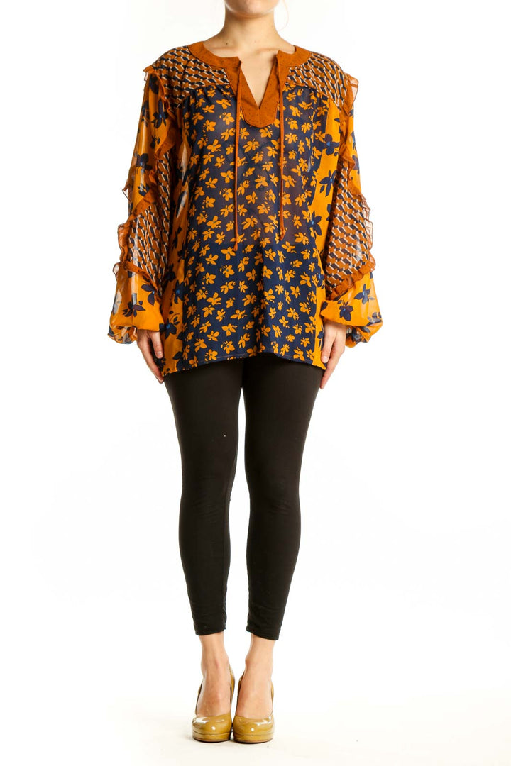 Navy and orange floral Cabi blouse with textured bell sleeves and tie neckline, front view on model