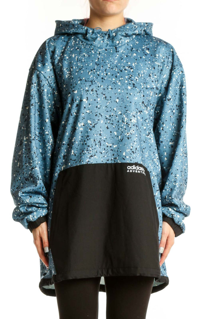 Adidas blue speckled cropped hooded jacket with white splatter pattern and black contrast panel, front view on model