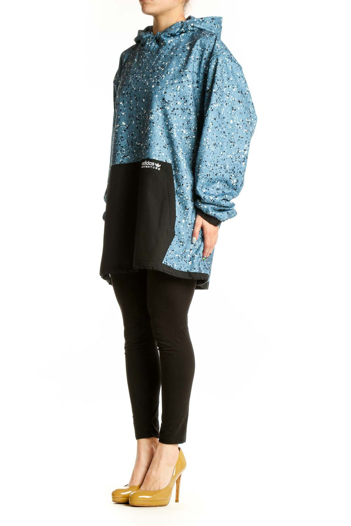 Adidas blue speckled cropped hooded jacket with white splatter pattern and black contrast panel, front view on model
