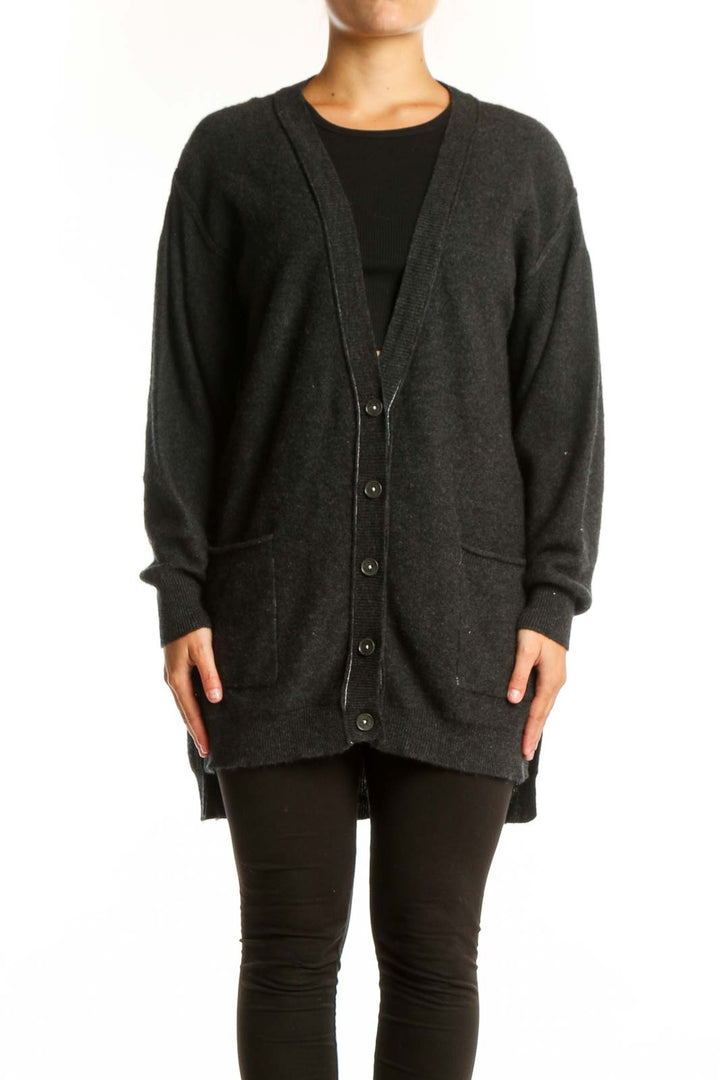 Charcoal cashmere button-front cardigan with pockets worn over black top, front view