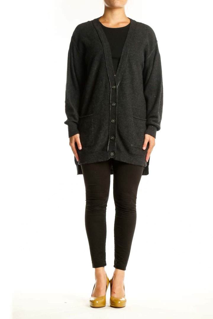 Charcoal cashmere button-front cardigan with pockets worn over black top, front view