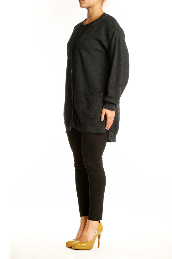 Charcoal cashmere button-front cardigan with pockets worn over black top, front view