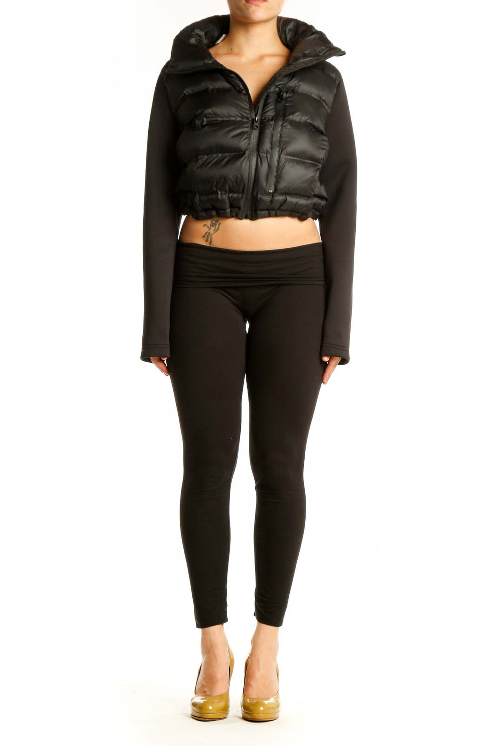 Black cropped puffer jacket with knit sleeves and quilted nylon front, worn with black pants