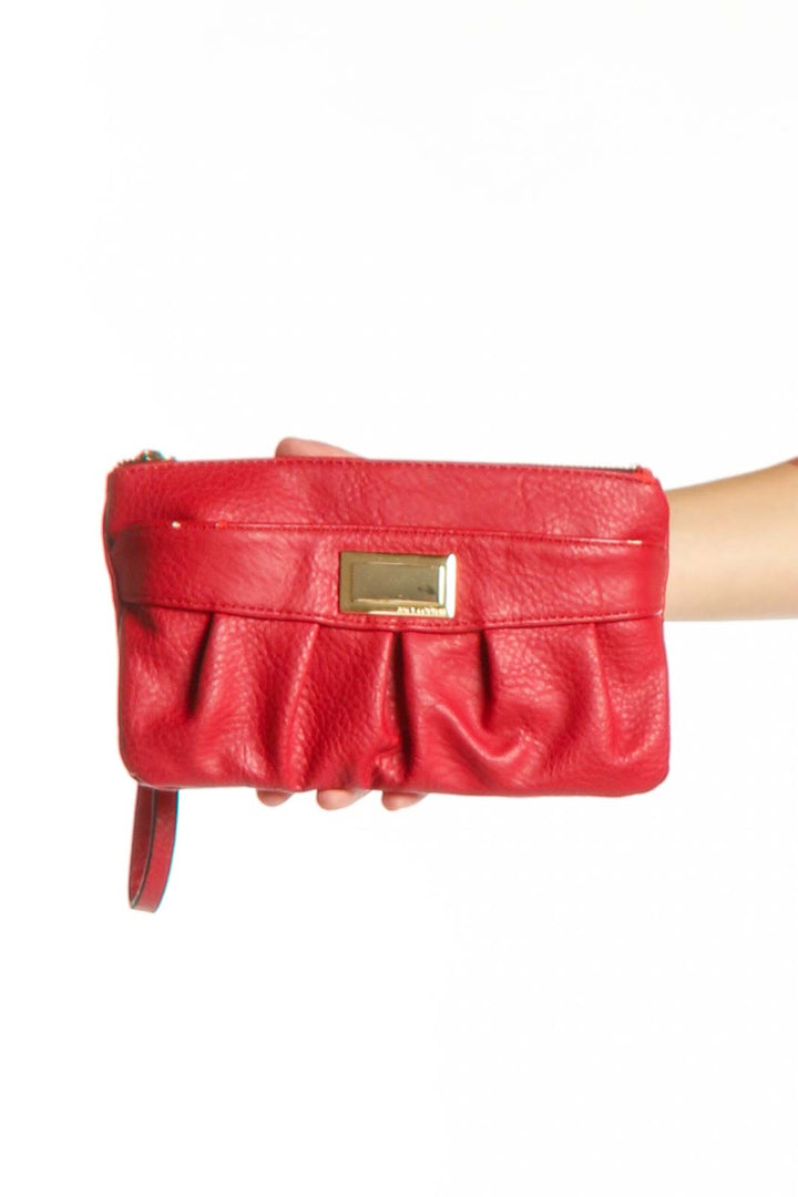 Red leather pleated clutch with gold-tone metal plate detail and wristlet strap by Juicy Couture