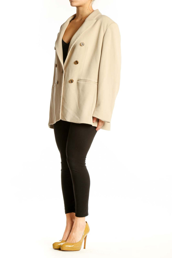 Cream double-breasted blazer with brown buttons, front view on model