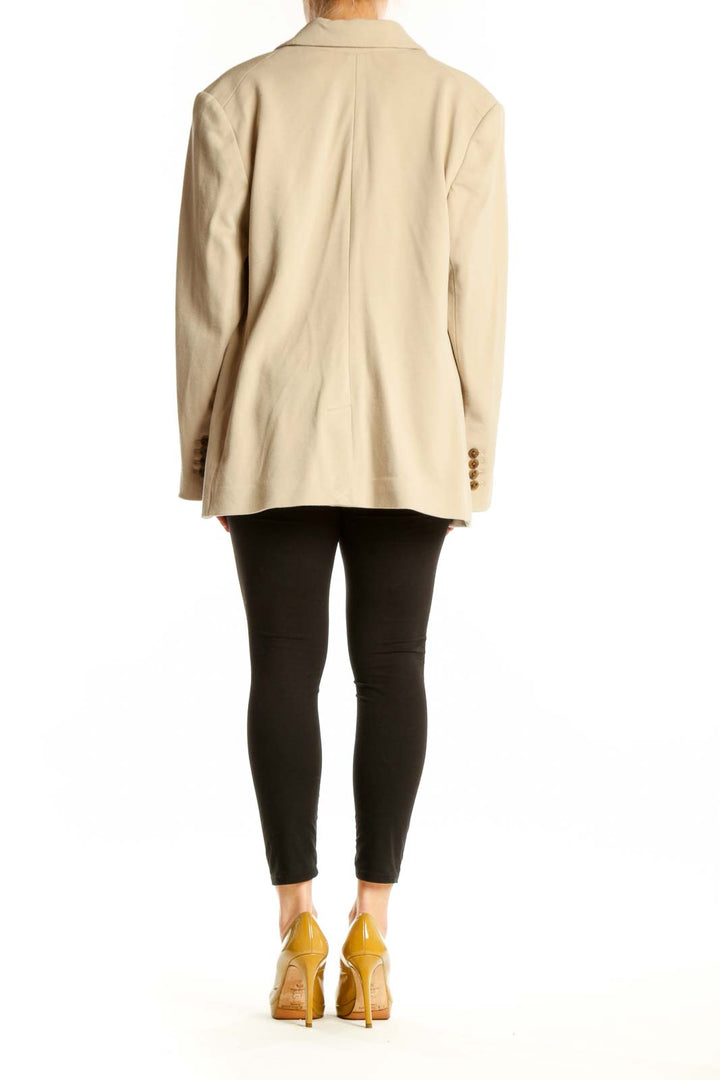 Cream double-breasted blazer with brown buttons, back view on model