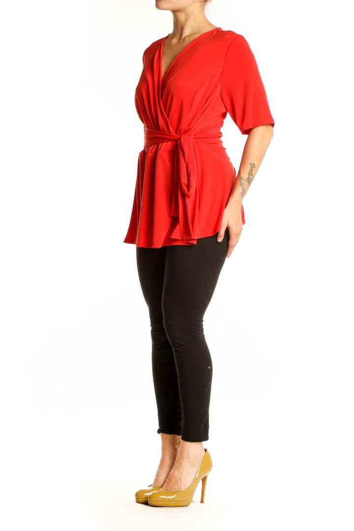 Red wrap blouse with tie waist and three-quarter sleeves, front view on model