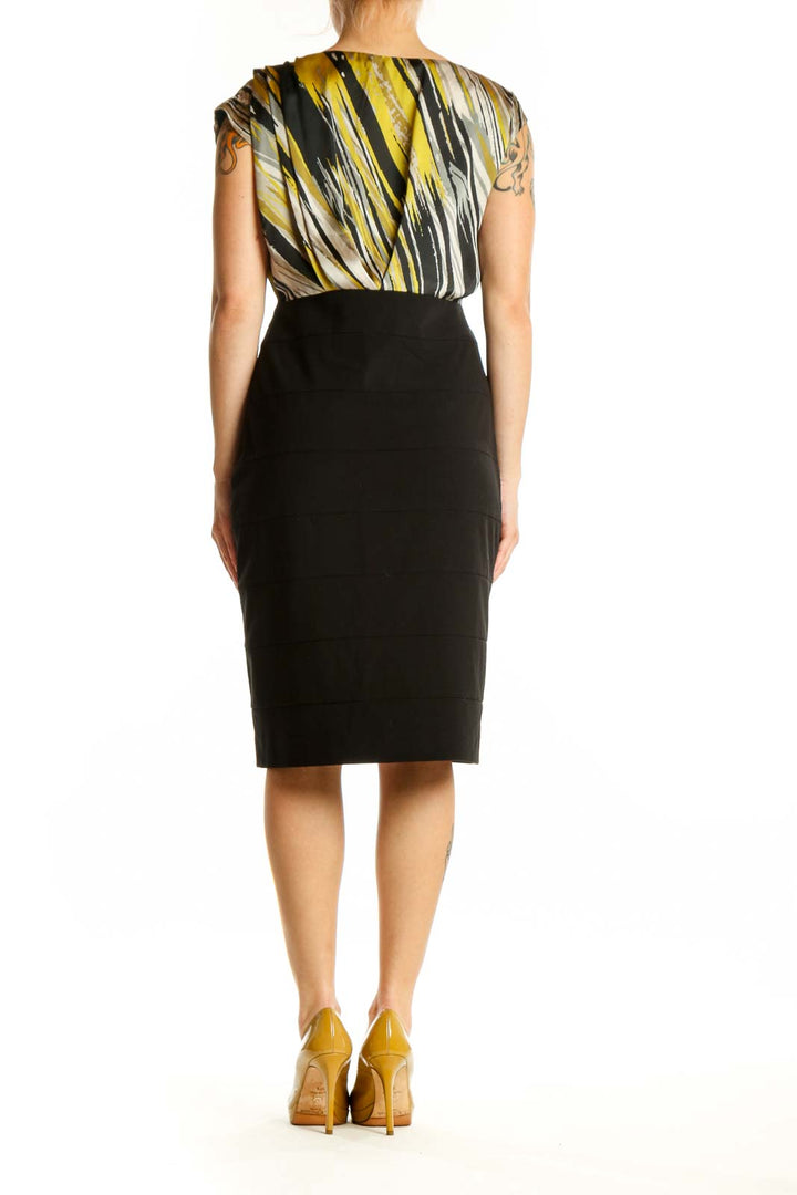 Black and gold striped wrap dress with black pencil skirt, back view on model