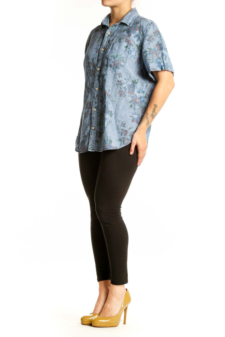 Blue floral button-up shirt with short sleeves and botanical print, front view
