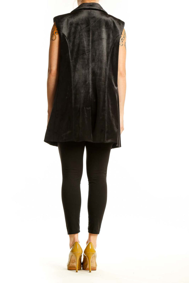 Black velvet blazer vest with scattered snowflake details, back view, styled with black leggings and gold heels