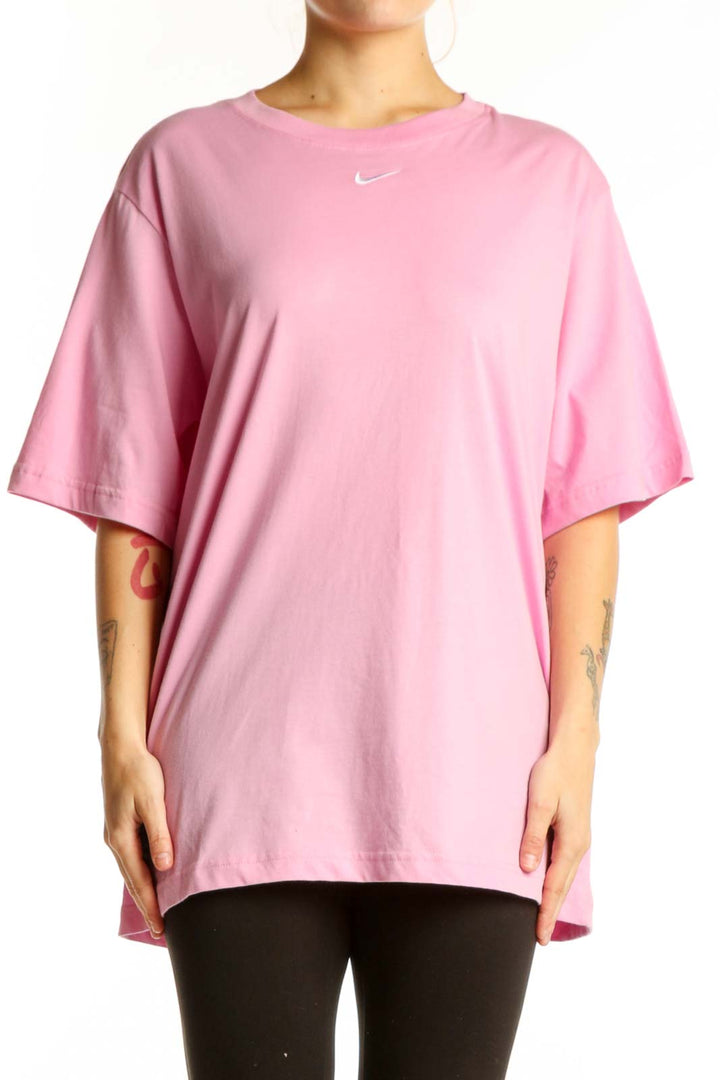 Pink cotton Nike oversized t-shirt with Swoosh logo, front view on model