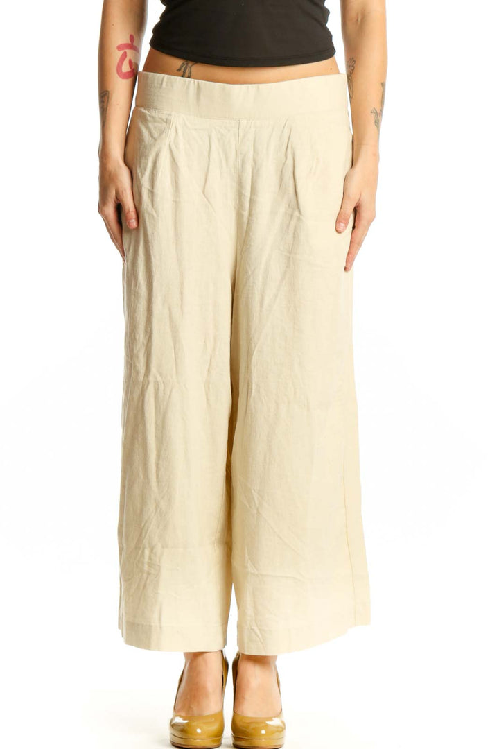 Front view of cream linen wide-leg cropped pants with elastic waistband and side pockets