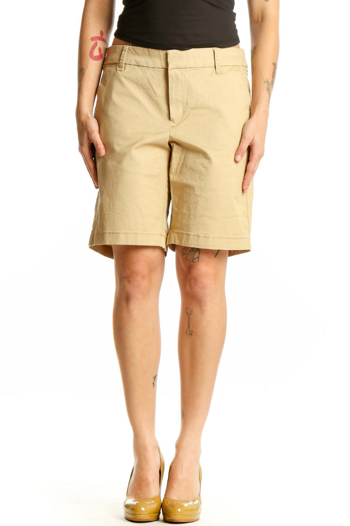 Front view of beige cotton Bermuda shorts with tailored fit and front pockets