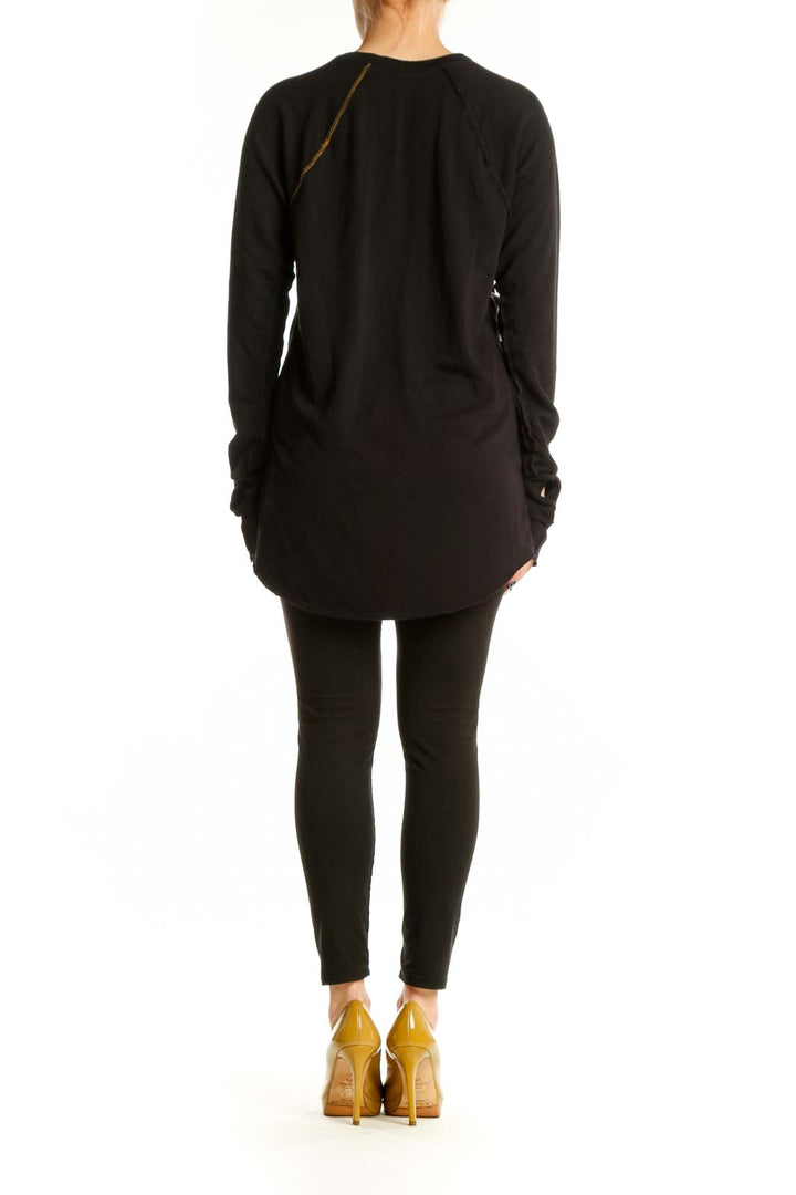 Black long sleeve tunic dress with gold side seam piping, back view styled with black leggings