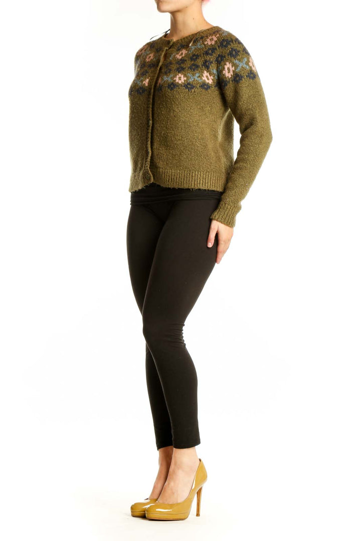 Olive green Fair Isle cardigan with cream and navy patterned yoke, button-front closure, worn with black pants