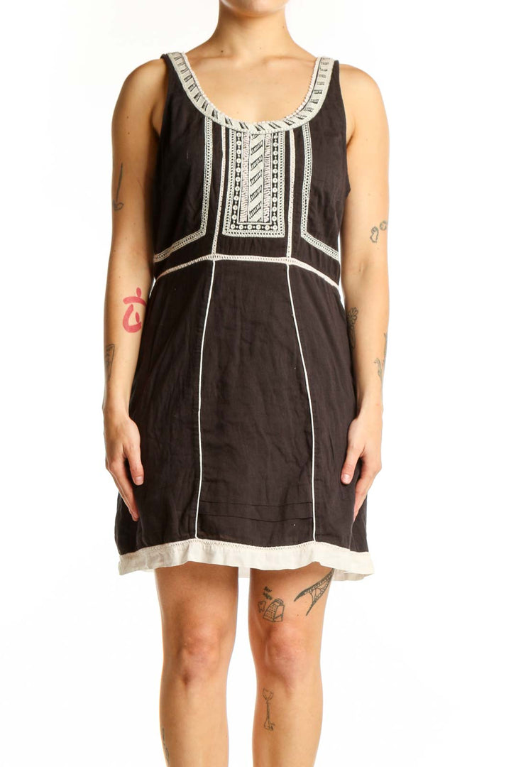 Black cotton Free People dress with white embroidered neckline and geometric chest detailing, front view