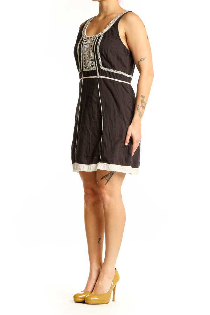 Black cotton Free People dress with white embroidered neckline and geometric chest detailing, front view