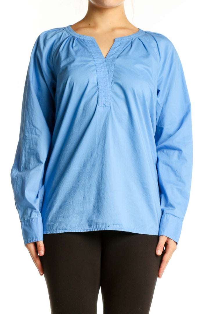 Blue cotton long sleeve henley top with gathered neckline, front view on model