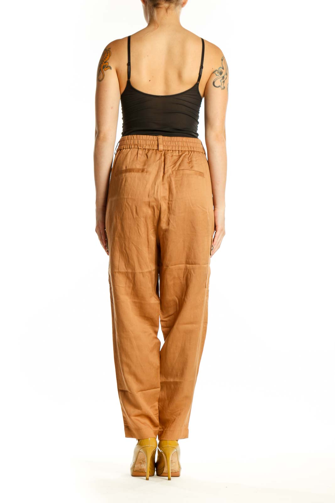 Back view of camel cargo pants showing cropped ankle length and rear pocket details