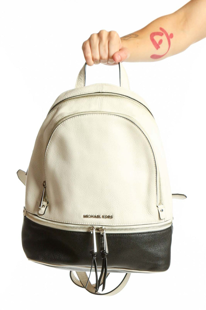 Cream and black Michael Kors leather backpack with dual-zipper closure and padded handles, front view