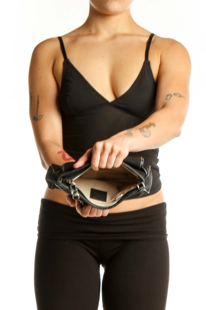 Black studded clutch worn as shoulder bag, displaying back view and dual shoulder straps