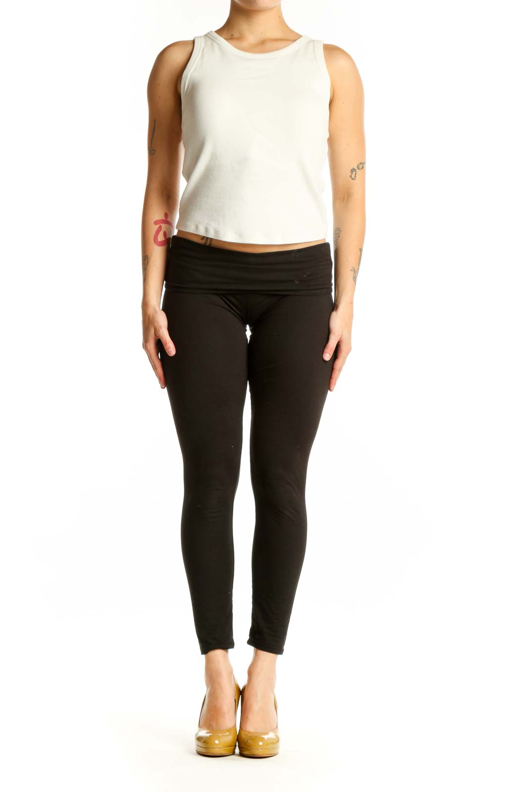 Cream ribbed sleeveless tank top worn with black leggings, front view