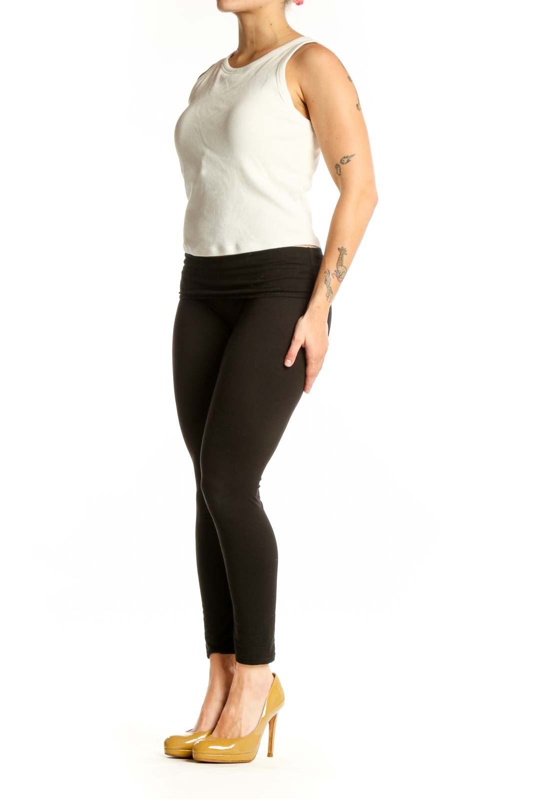 Cream ribbed sleeveless tank top worn with black leggings, front view