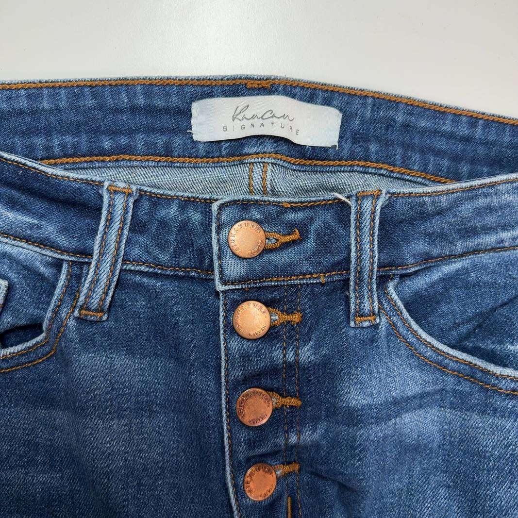 Tag view of blue distressed skinny jeans with ripped knees by Kancan, showing classic five-pocket design