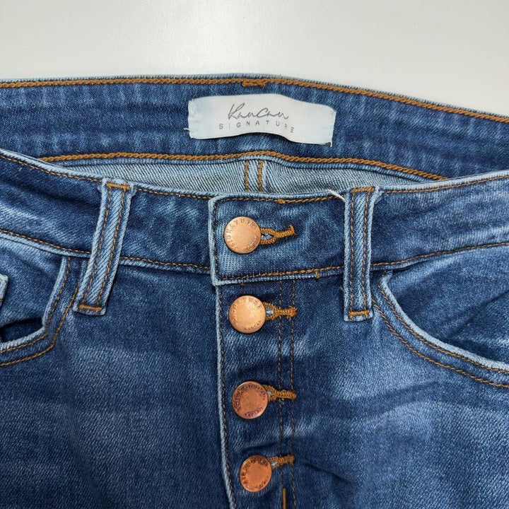 Tag view of blue distressed skinny jeans with ripped knees by Kancan, showing classic five-pocket design