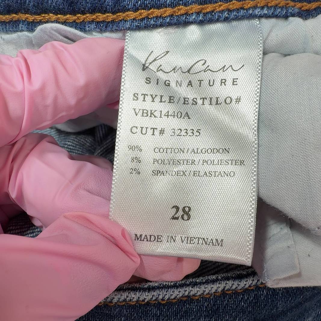 Tag view of blue distressed skinny jeans with ripped knees by Kancan, showing classic five-pocket design