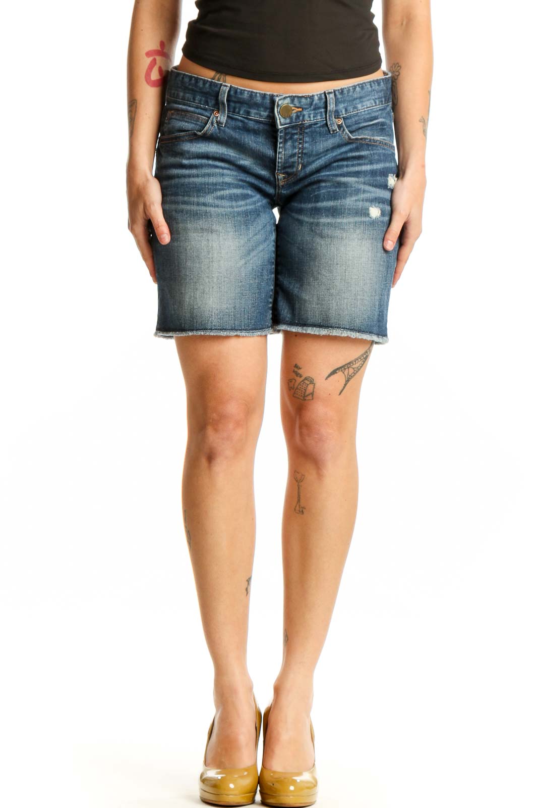 Blue denim distressed shorts front view, medium wash with ripped details, worn with black crop top