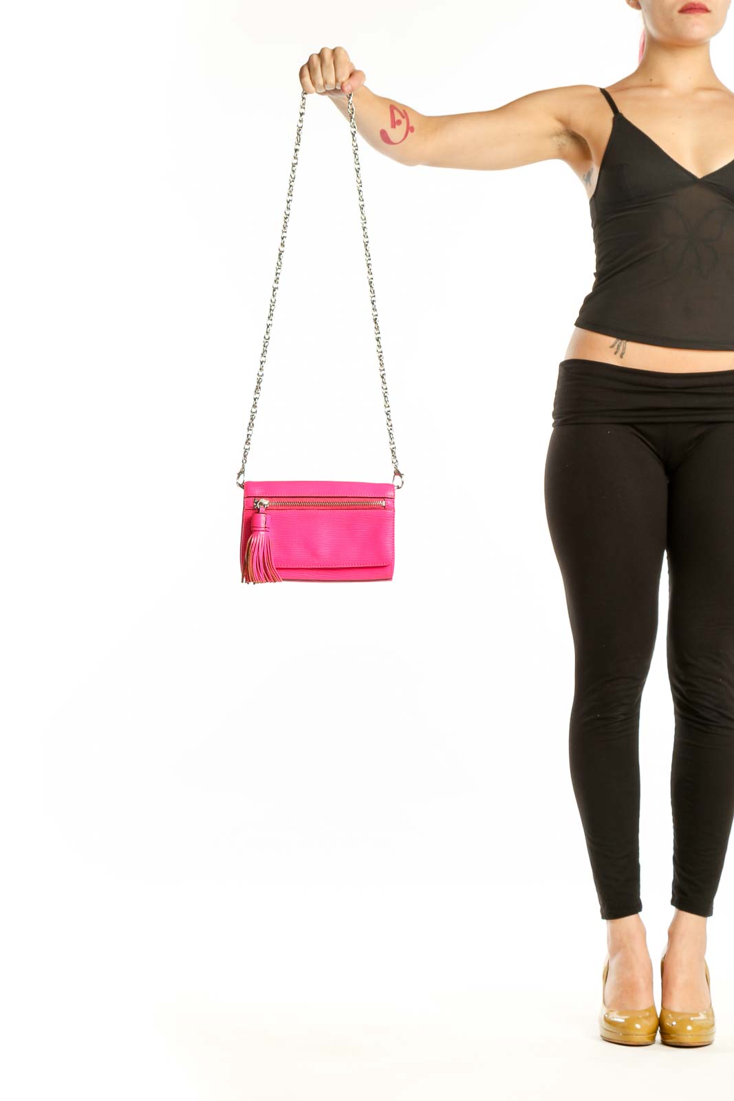 Hot pink Rebecca Minkoff leather crossbody bag with silver chain strap and tassel accent, held by hand