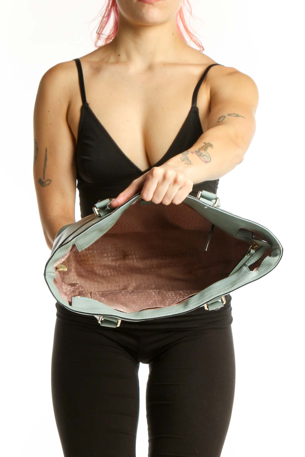 Back view of mint green Kate Spade tote bag worn by model, showing structured design and handles