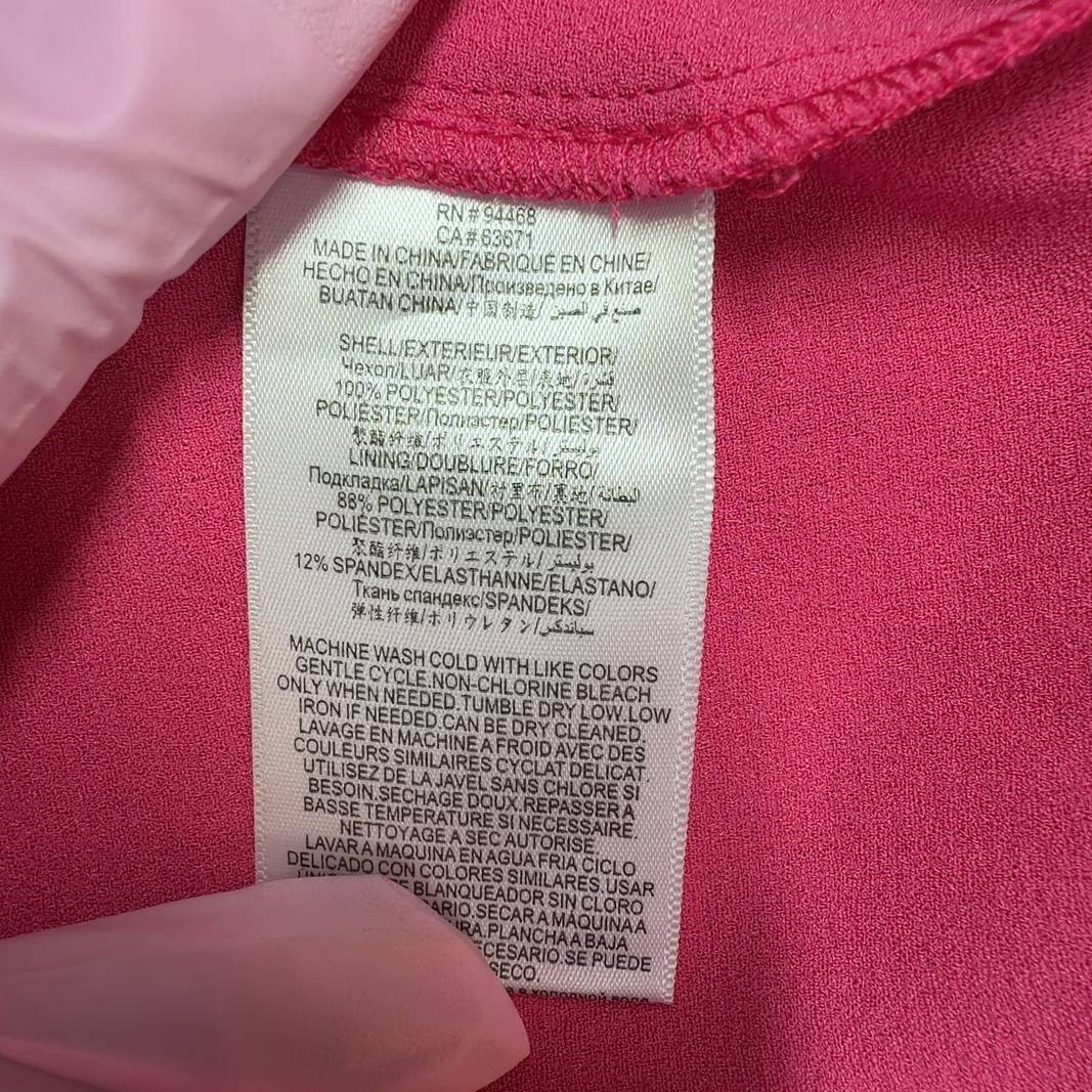Tag view of pink ruffle cap sleeve A-line dress showing elegant ruffled details