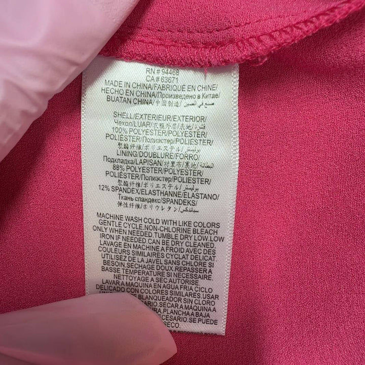 Tag view of pink ruffle cap sleeve A-line dress showing elegant ruffled details