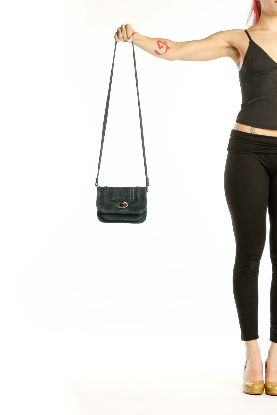 Teal cotton crossbody bag with gold-tone turnlock closure and adjustable strap, held by hand