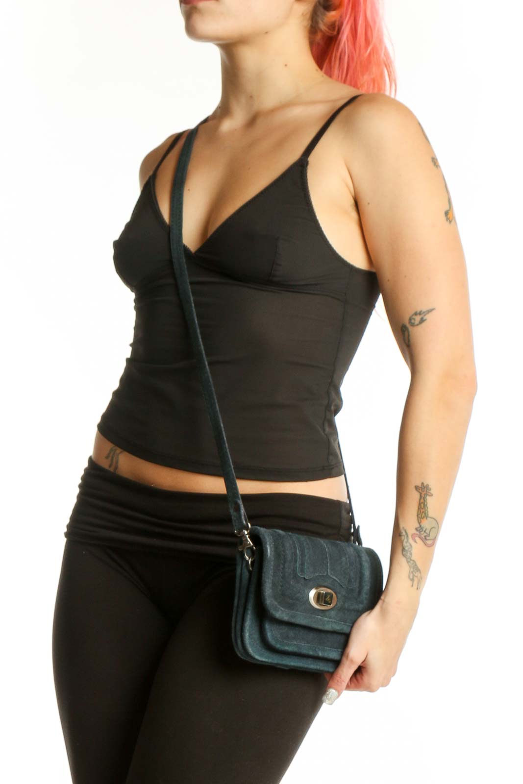 Teal cotton crossbody bag with gold-tone turnlock closure and adjustable strap, held by hand
