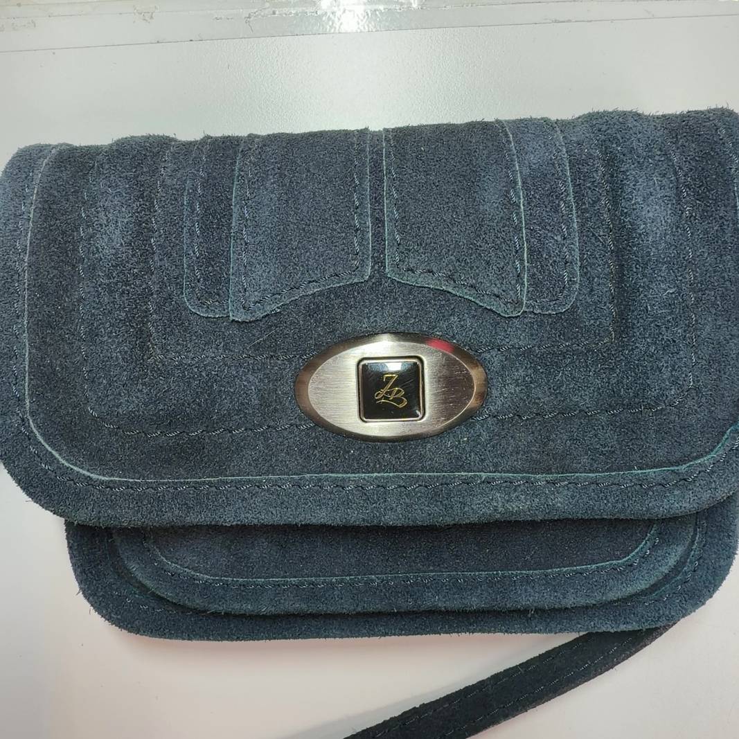 Teal cotton crossbody bag worn as crossbody style on model, showing back view and strap placement