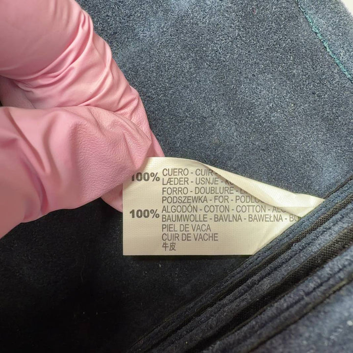 Teal cotton crossbody bag worn as crossbody style on model, showing back view and strap placement