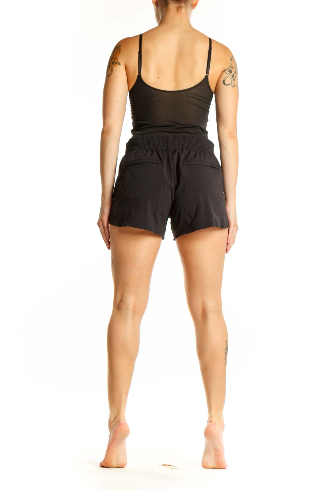 Black Athleta athletic shorts shown from back view, displaying flattering silhouette and side vent details
