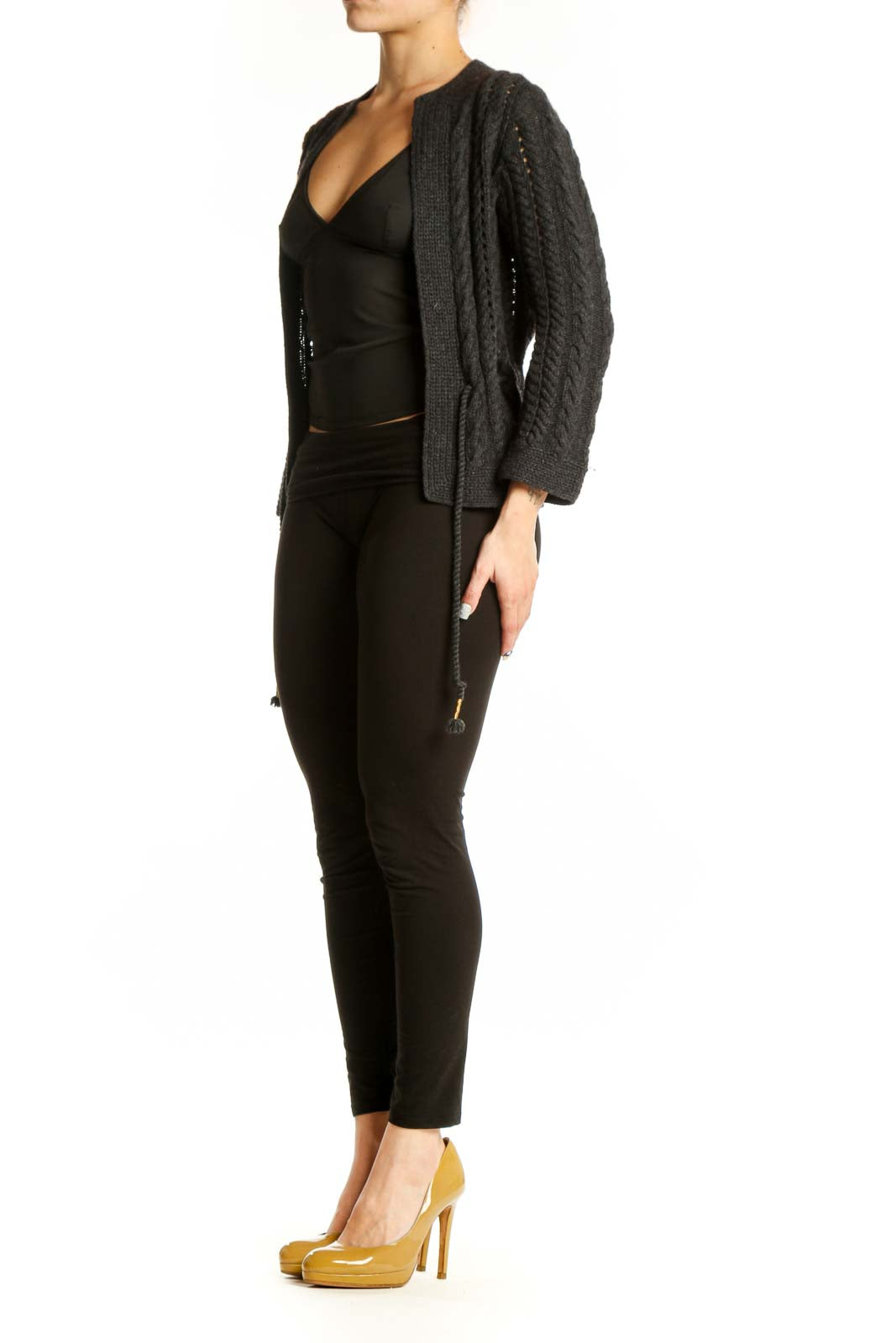 Charcoal cable knit cardigan with open front and tassel tie details, worn over black top