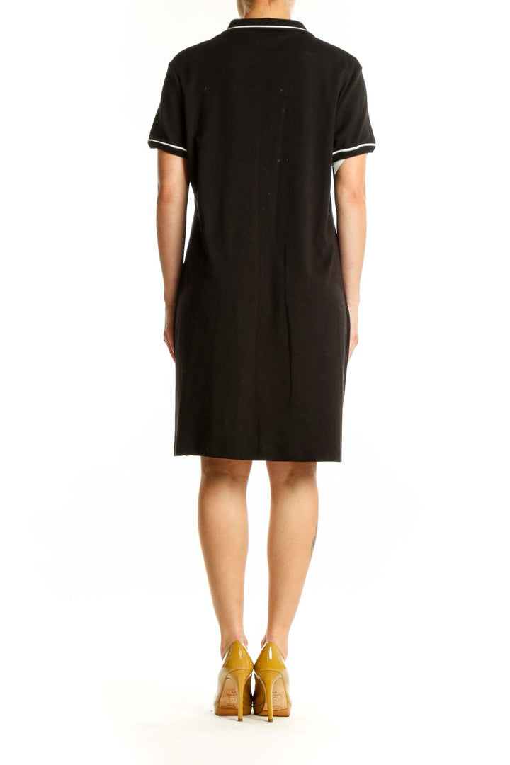 Black cotton polo shirt dress with white-tipped collar, back view showing A-line silhouette