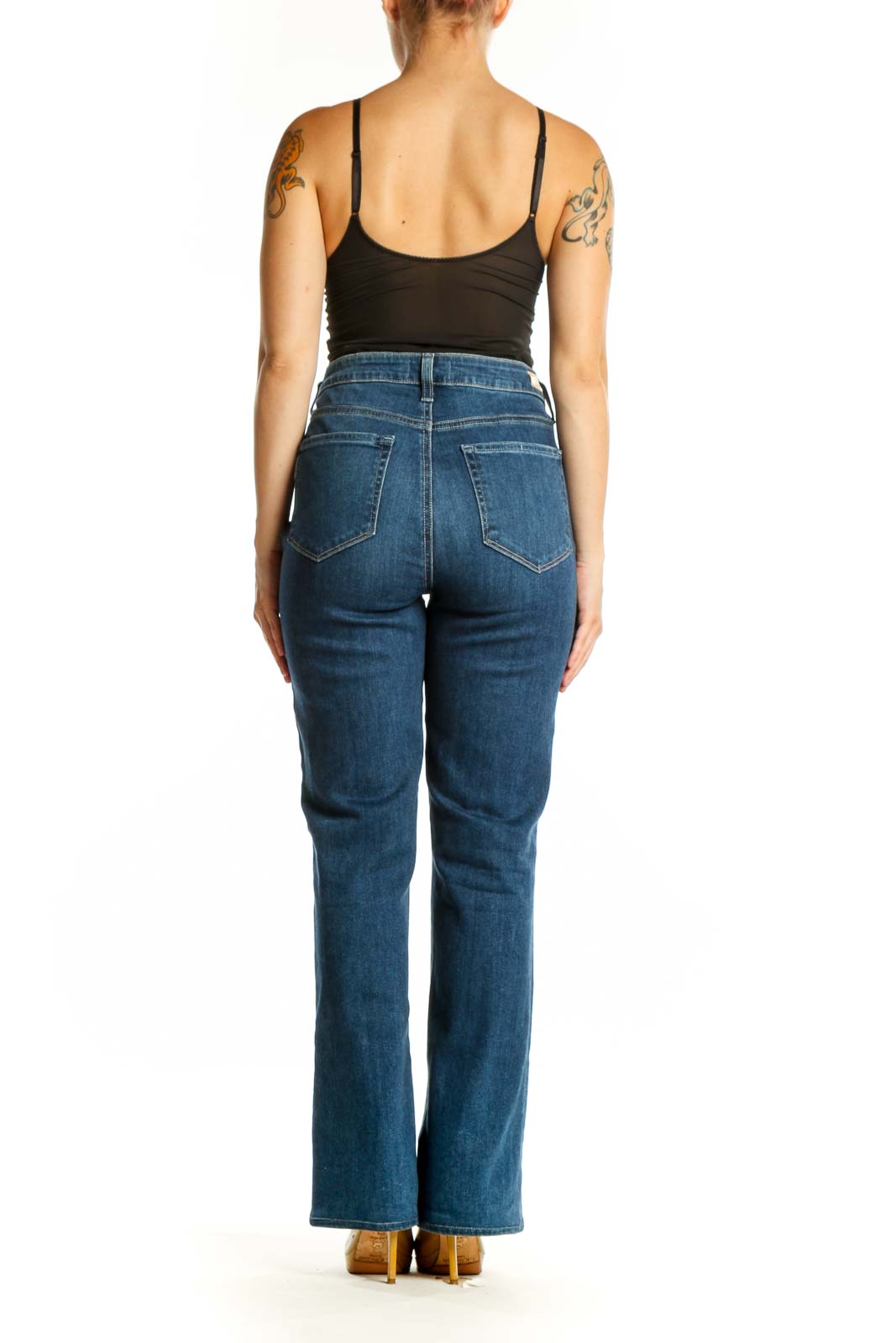 Woman wearing blue high-waisted flare denim jeans by Paige, back view showing flare silhouette
