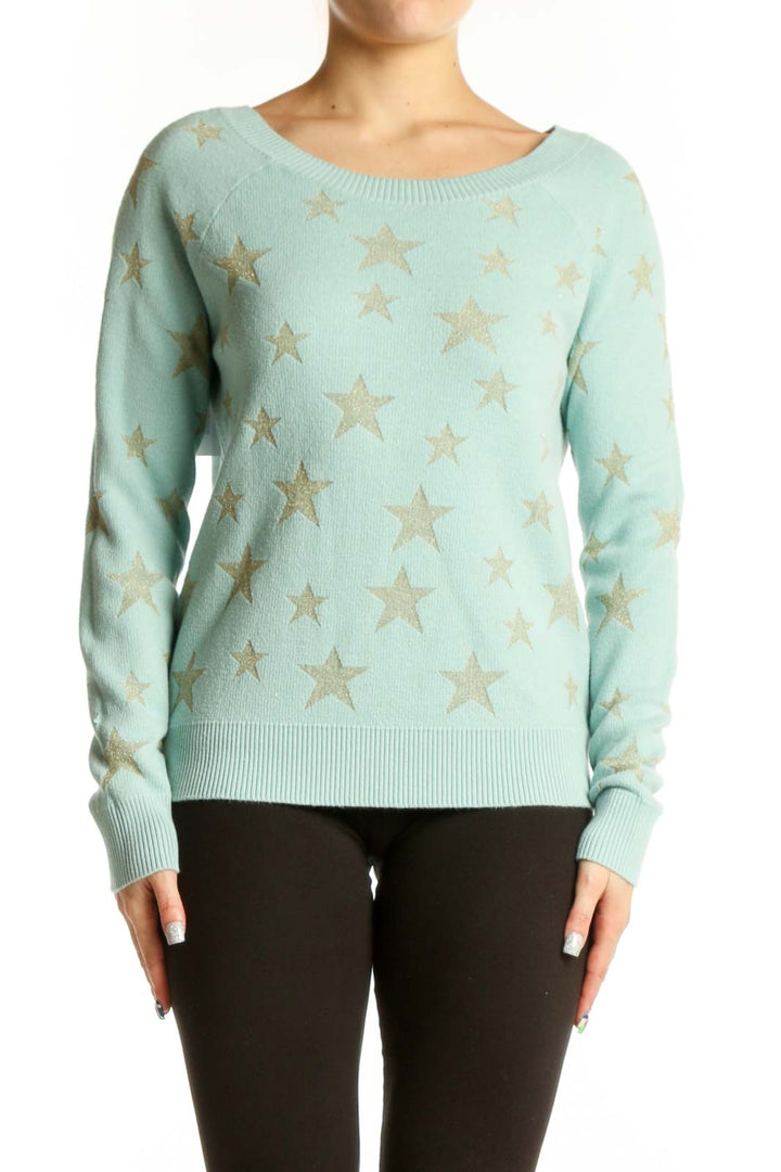 Mint green knit sweater with gold star pattern, front view on model wearing black pants