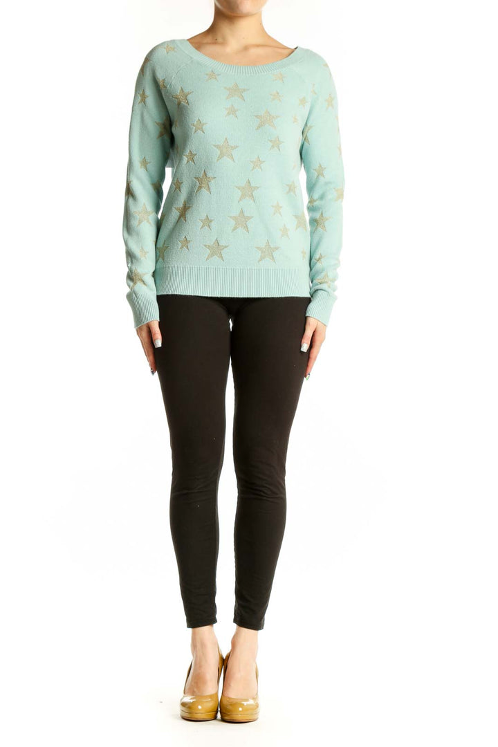 Mint green knit sweater with gold star pattern, front view on model wearing black pants