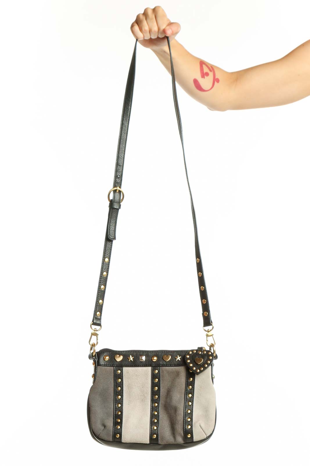 Black and cream studded leather crossbody bag with gold heart embellishments and adjustable strap