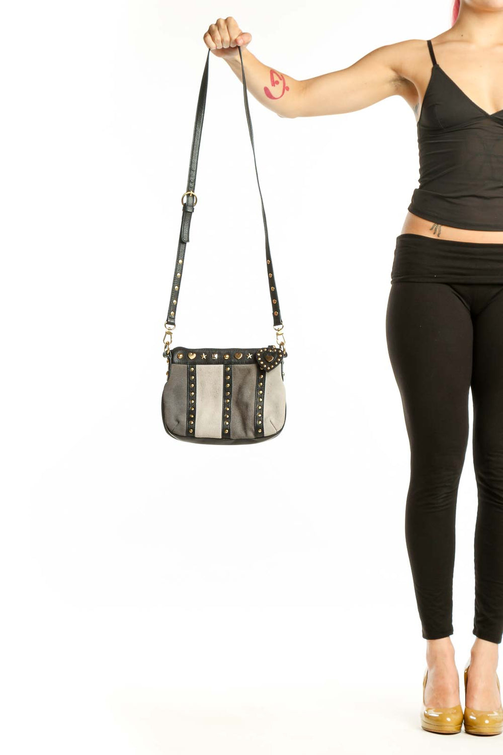 Black and cream studded leather crossbody bag with gold heart embellishments and adjustable strap
